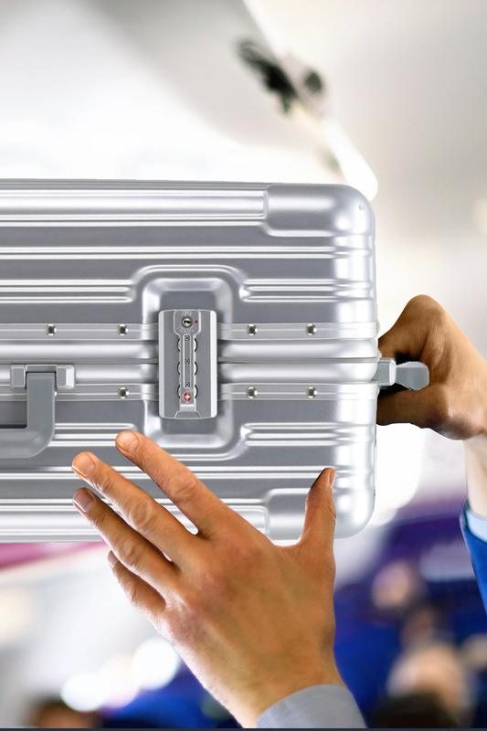 Telescopic handle and TSA combination lock on the Flight Knight suitcase, held up to an aircraft overhead locker